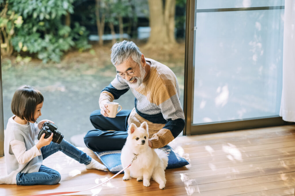 アートプロ有限会社の理念イメージです。縁側で談笑する祖父と娘の仲睦まじい人生の一瞬を切り取っています。